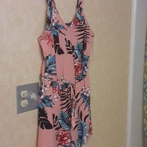 Coral short sleeve romper with flowers and leaves.